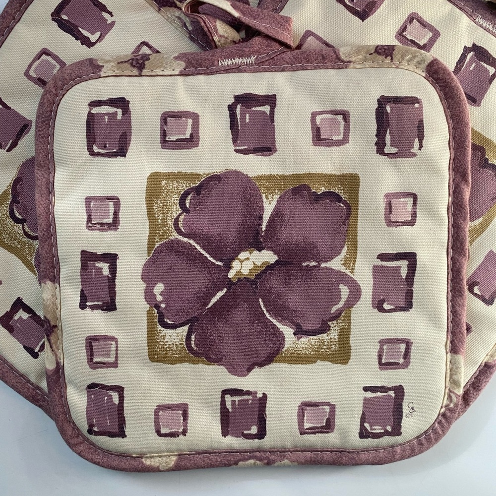 Set of four purple and off white flower potholders